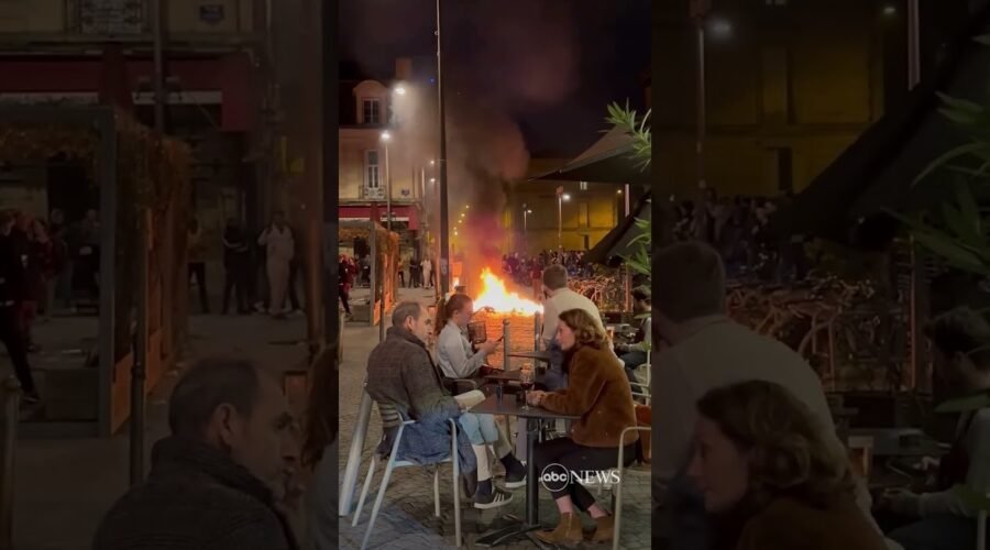 French diners enjoy wine as fire lit by protesters burns nearby | ABC News